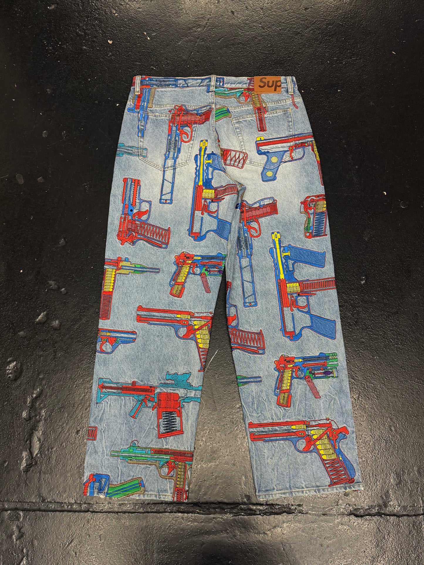 SUPREME GUNS EMBROIDERED JEANS (PRE-OWNED)